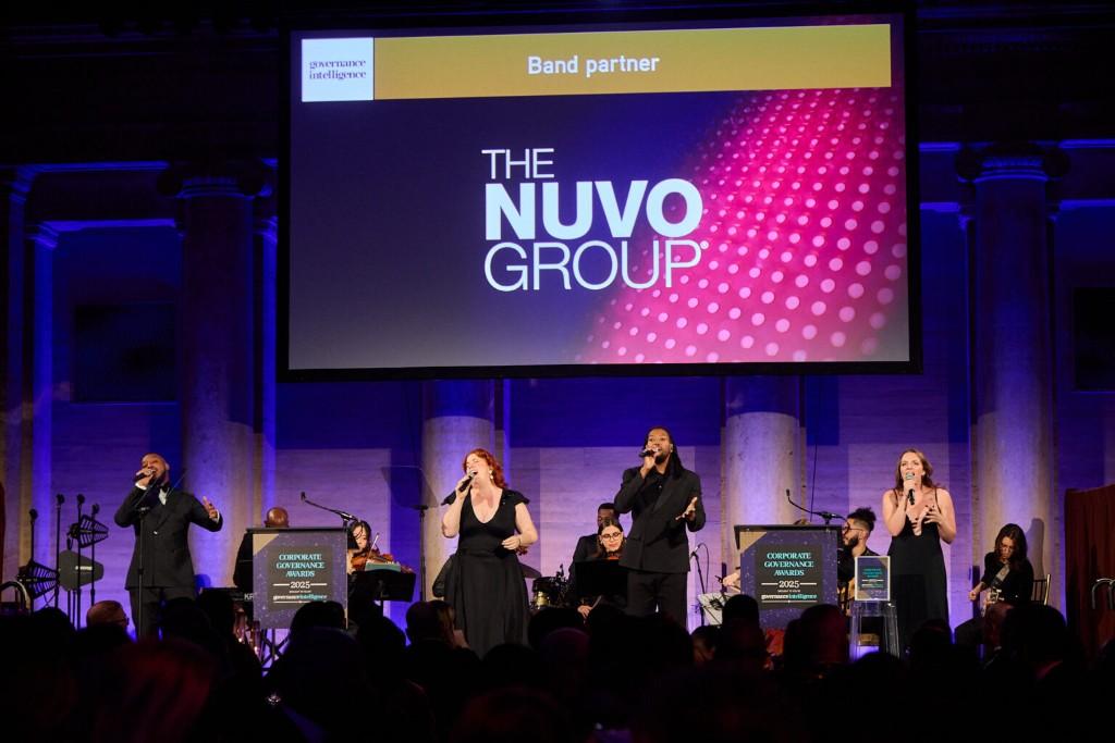 Four vocalists and full ensemble on stage at a corporate awards gala