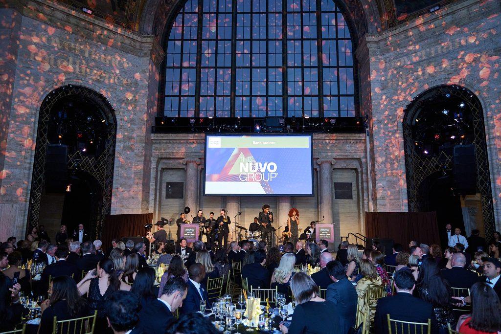 Wide view of a full live band performing for a formal gala audience